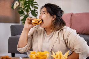 一個BMI過重的女性正在進食一個漢堡